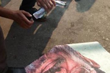 متظاهرون يحرقون لافتة ” النهضة إرادة شعب ” وصور الرئيس مرسي