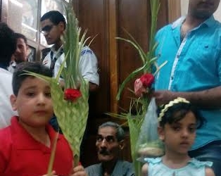 الأطفال ملوك بتيجان السعف المزينة بالورود بكنيسة بعين شمس