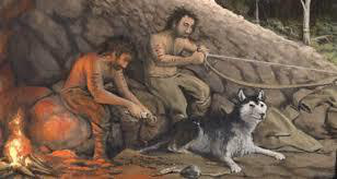 Illustration of early humans inside a cave with a wolf.