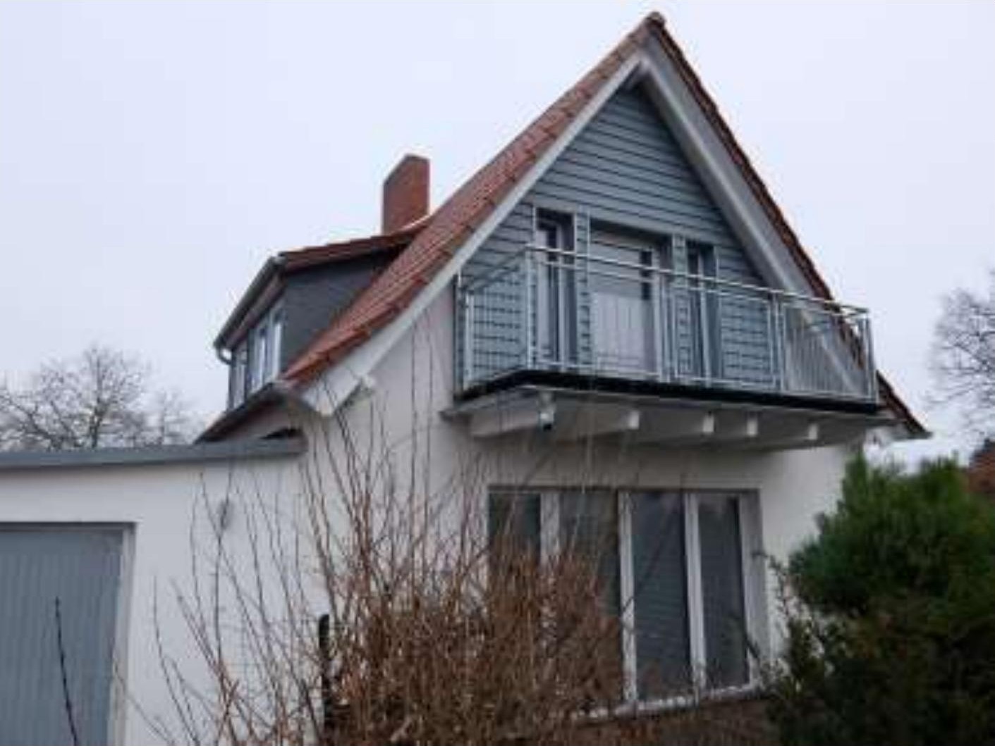 Seitenansicht eines Zweifamilienhauses mit Satteldach, Balkon und angrenzender Garage in Wernigerode