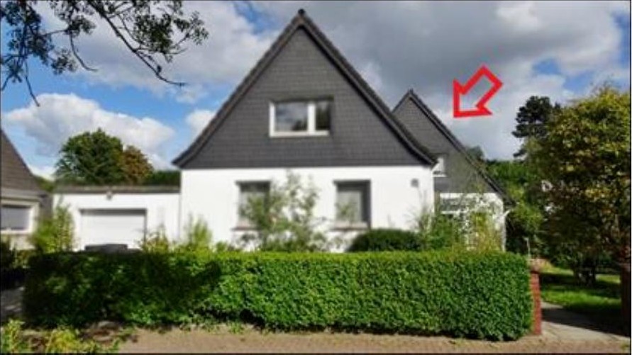 Einfamilienhaus mit weißer Fassade, dunklem Satteldach und Vorgartenhecke, Ansicht von vorne
