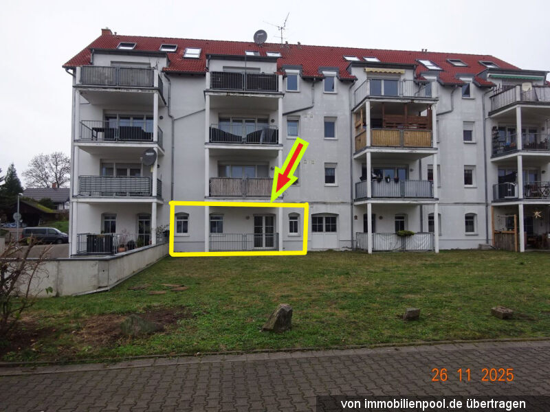 Fassade eines Mehrfamilienhauses in Taucha, Alte Salzstr. 4, mit markierter Eigentumswohnung im Erdgeschoss, weiß verputzt, rotes Dach, Balkone, Vorgarten mit Rasen