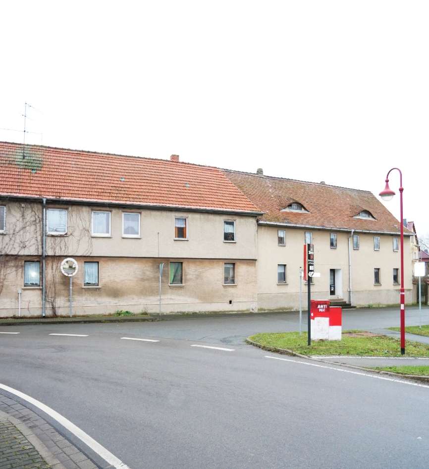 Einfamilienhaus in Am Ettersberg OT Vippachedelhausen 2, Ansicht der Seitenfassade mit rotem Ziegeldach und beigefarbener Wand, Straßenanschluss mit Laternenmast und Briefkasten