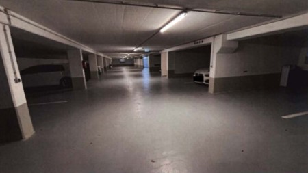 Untergeschoss-Garage mit Betonboden und Stützpfeilern, beleuchtet durch Deckenleuchten, Teil der Eigentumswohnung Vitztumstraße 20, 85368 Moosburg an der Isar