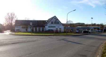 Gebäude an der Flensburger Straße 25 in Sterup, 24996, mit weißer Fassade und dunklem Dach, umgeben von Grünfläche und Straßenbeleuchtung