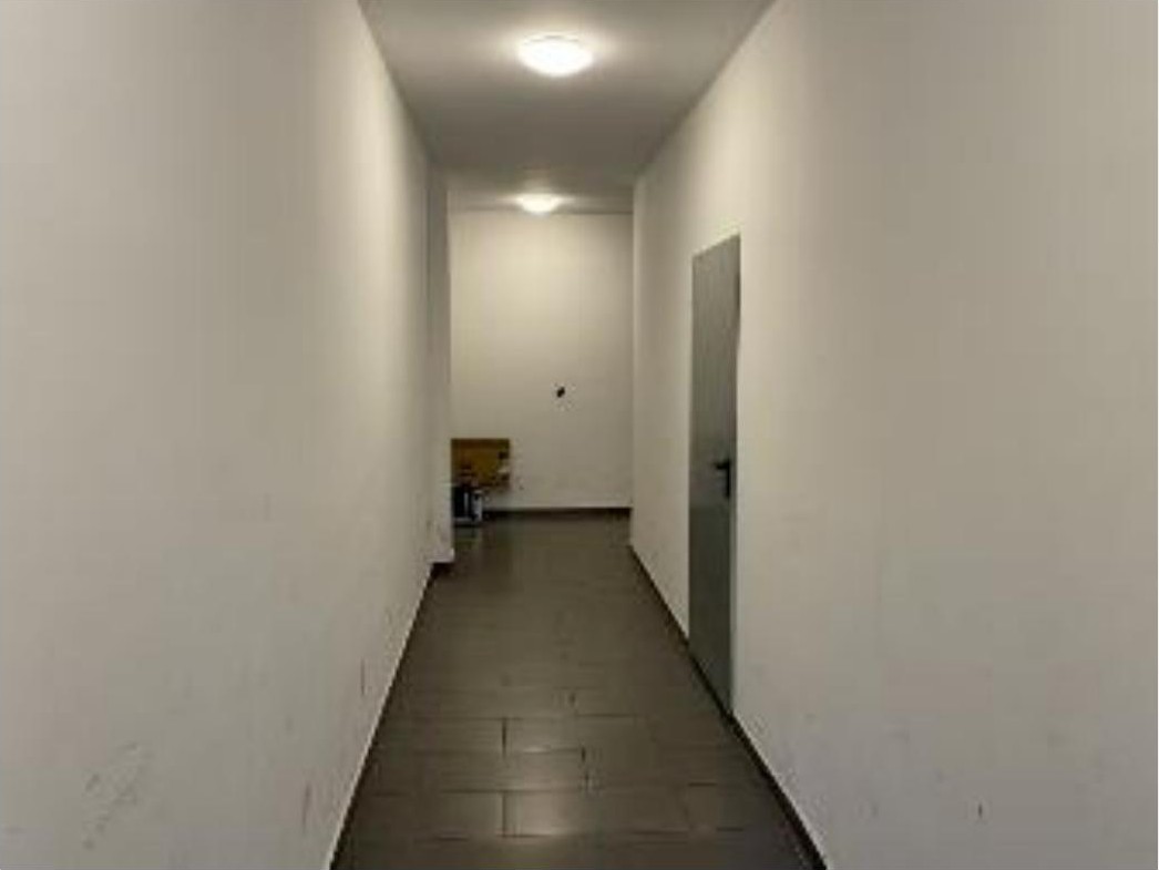 Lichter Flur mit weißen Wänden und Fliesenboden, Tür rechts, Karton am Ende, Teil eines Keller- oder Hobbyraums in Köln, Odenwaldstraße 49