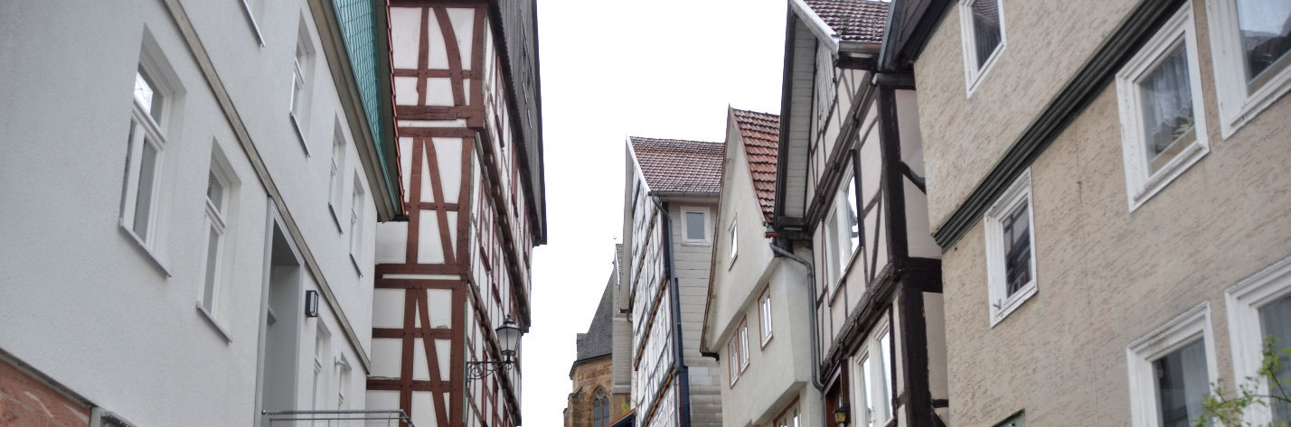 Außenansicht der Kornstraße 12 in Immenhausen, 34376, mit Fachwerkelementen und angrenzenden Gebäuden in einer engen Straße