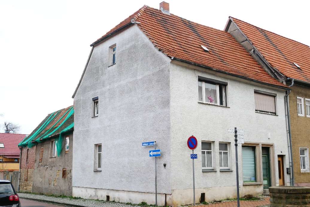 Einfamilienhaus in Roßleben-Wiehe, Leopold-von-Ranke-Str. 78, mit weiß verputzter Fassade und rotem Ziegeldach, Seitenansicht mit Straßenschildern