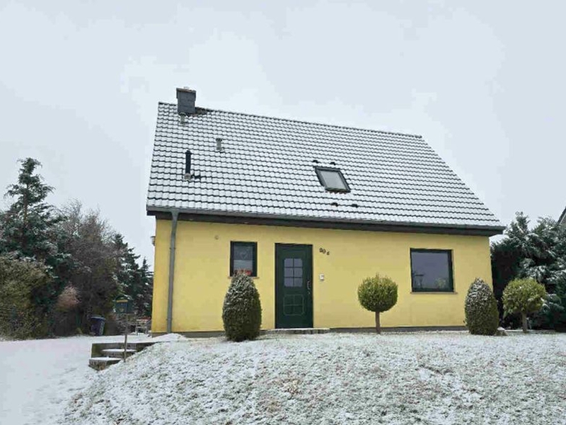Gelbes Einfamilienhaus mit schwarzem Satteldach, verschneiter Vorgarten, grüner Haustür und Fenstern, Dorstr. 29, Malchin OT Scharpzow