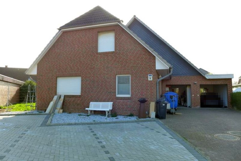 Einfamilienhaus in Kremperheide, Sachsenweg 6, mit rotem Backsteinfassade, Dachgauben, Garagenanbau und gepflastertem Vorgartenbereich