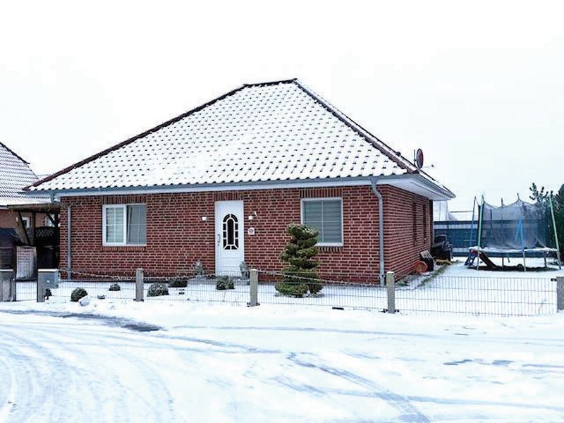 Einfamilienhaus aus roten Ziegeln mit schneebedecktem Dach, weißer Haustür, Fenstern und Metallzaun im Vorgarten, Schwerin, Kleiner Kamp 21