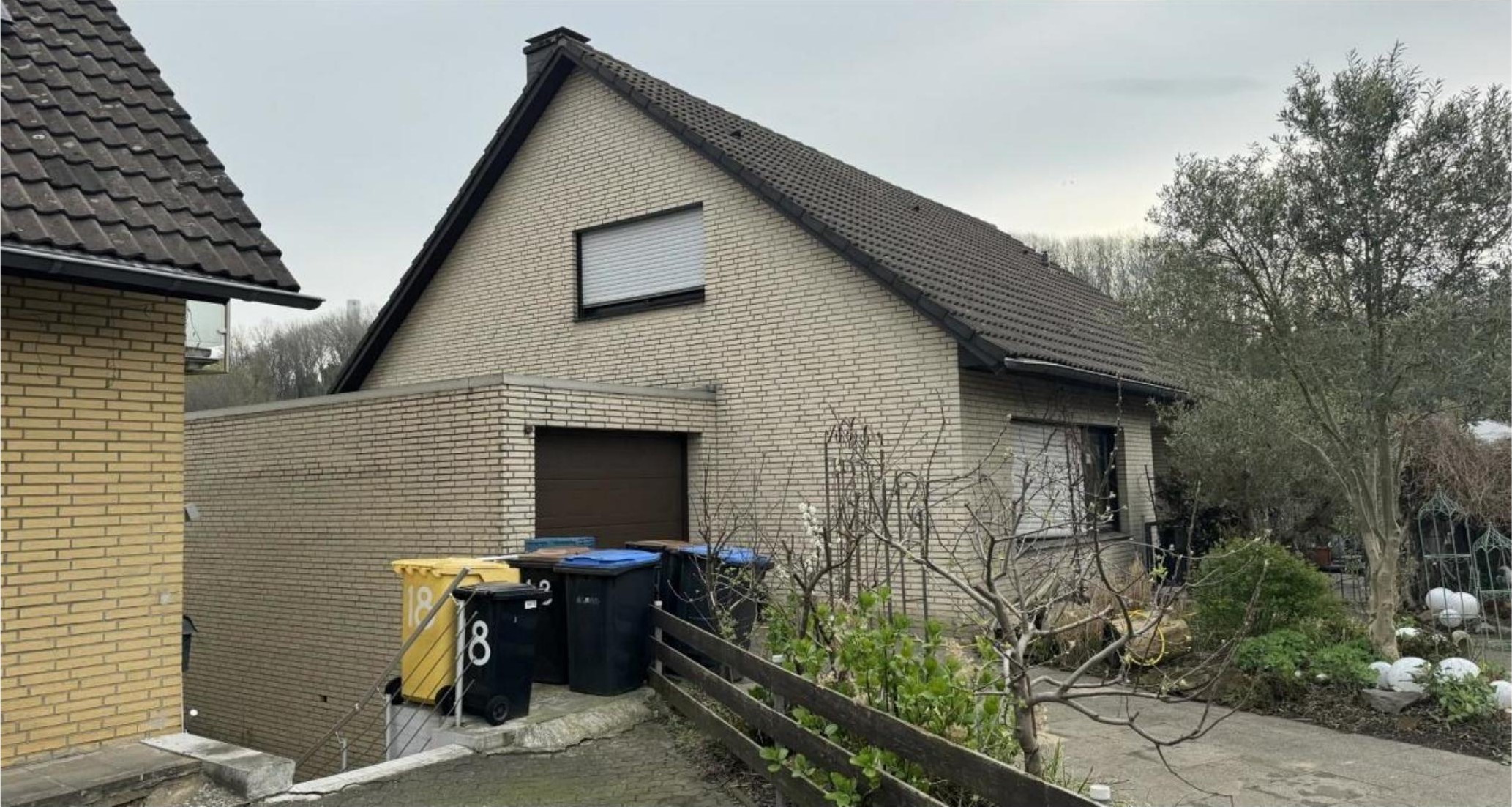Seitenansicht eines Einfamilienhauses mit Ziegelwand, Dach, Garagenzugang und Gartenbereich in Grevenbroich, Falkenstraße 16