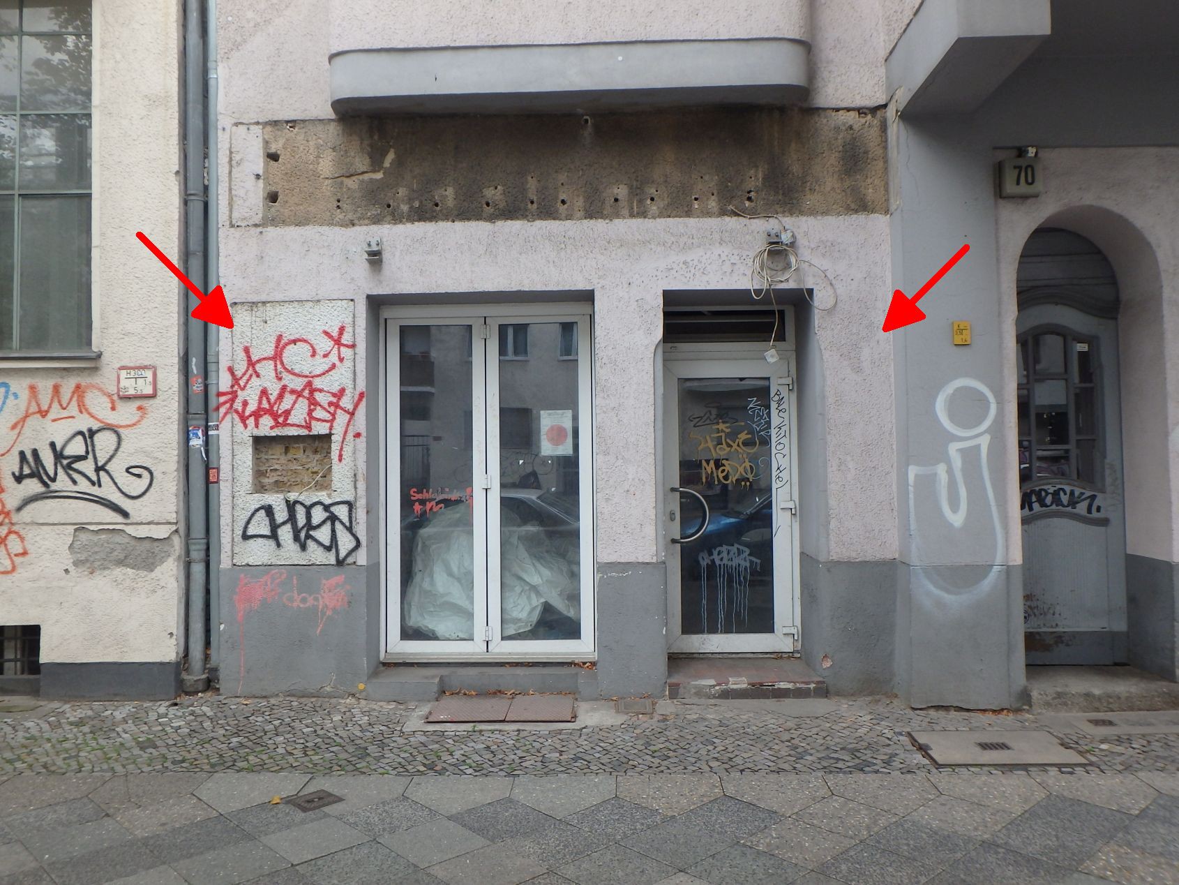 Eingangsbereich eines Gebäudes an der Leibnizstraße 70 in Berlin mit Glastür, Nebeneingang und Graffiti an der Fassade