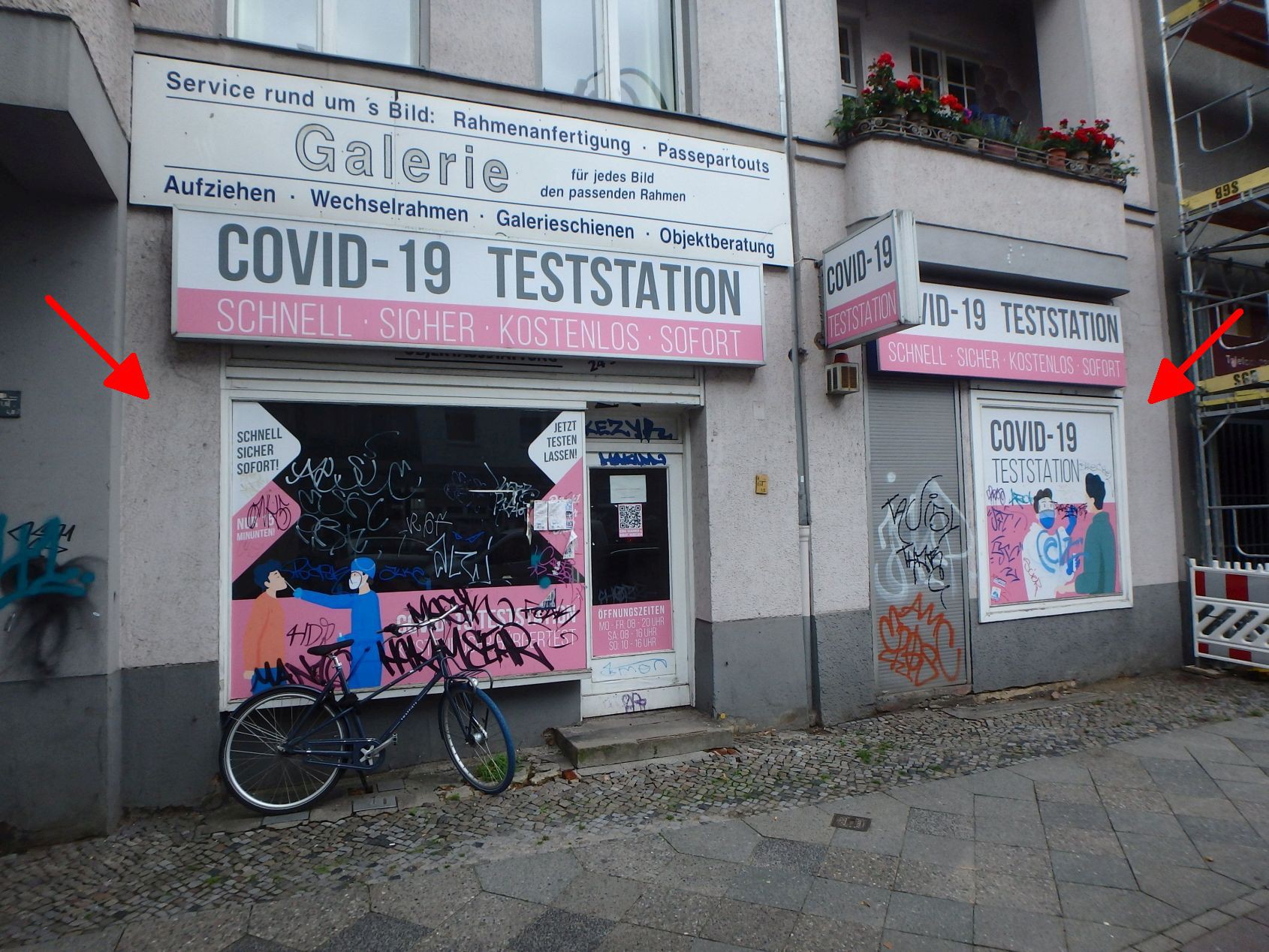 Fassade eines Gebäudes in Berlin, Leibnizstraße 70, mit Schildern für Galerie und COVID-19 Teststation, Fahrrad und Graffiti