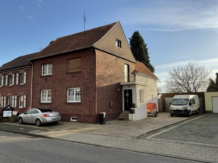 Vorderansicht eines Backsteinhauses in Gangelt, Brökerstraße 42, mit Eingang, Fenstern und geparkten Fahrzeugen