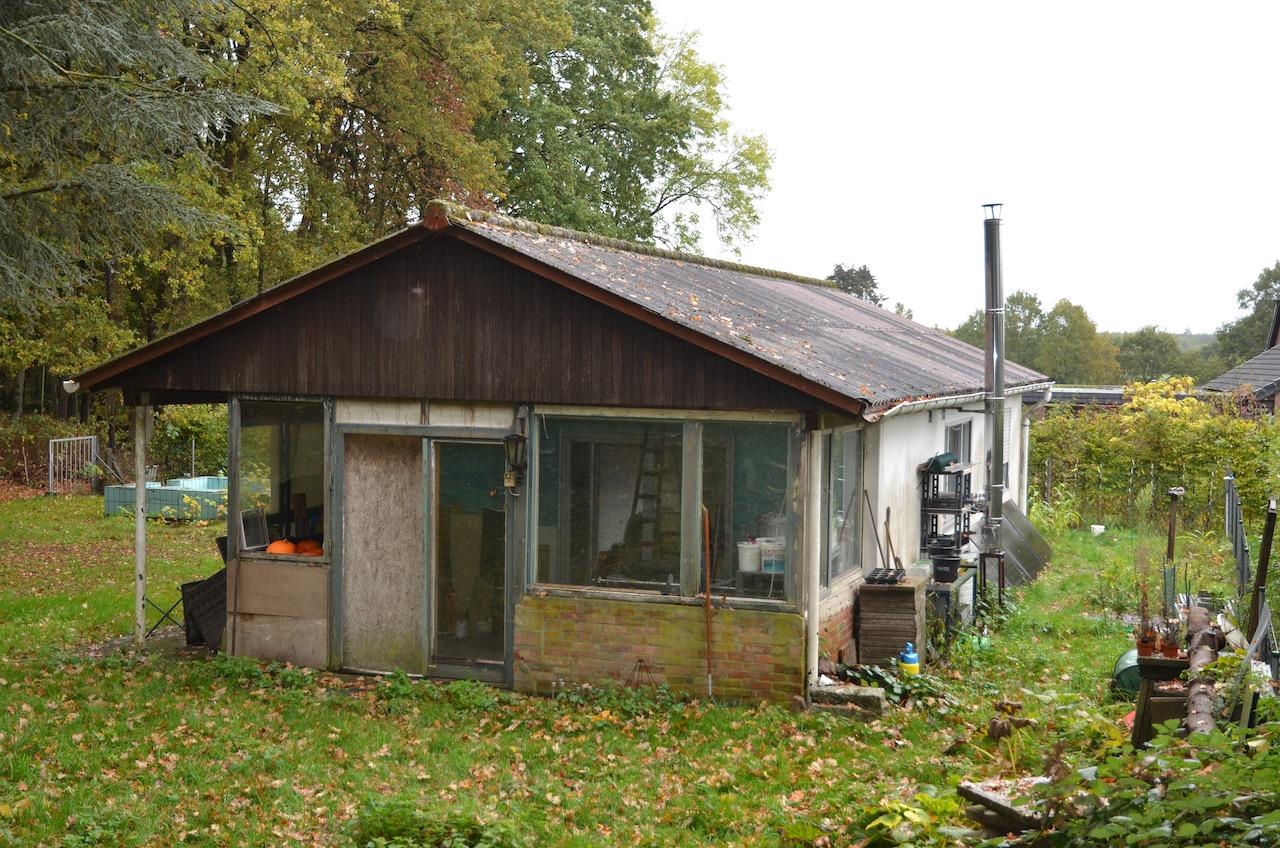 Gartenbereich mit Holzgebäude, Grünfläche, Bäumen und Gartenutensilien in Syke, Seufzerberg 7