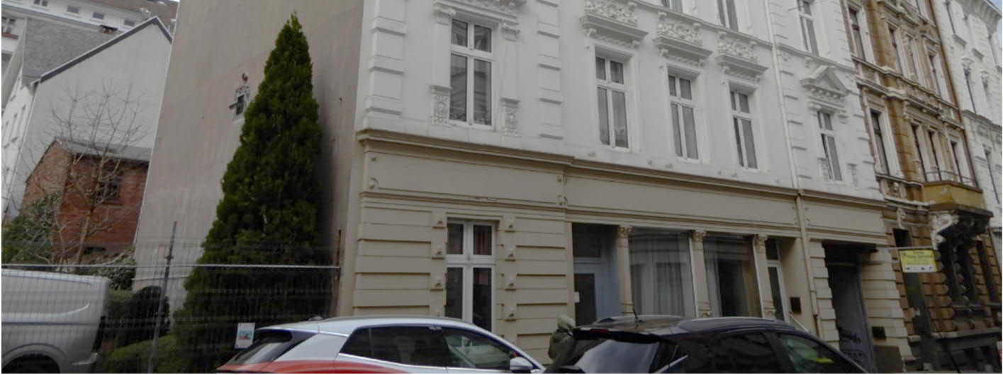 Fassade eines Wohn- und Geschäftshauses in Wuppertal, Wiesenstr. 48/48a, mit mehreren Fenstern und Eingängen im Erdgeschoss