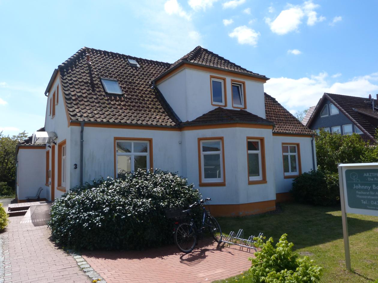 Zweistöckiges Wohn- und Geschäftshaus mit Satteldach, weißer Fassade und orangefarbenen Fensterrahmen, Hausnummer 3, Sudweyer Straße, Weyhe