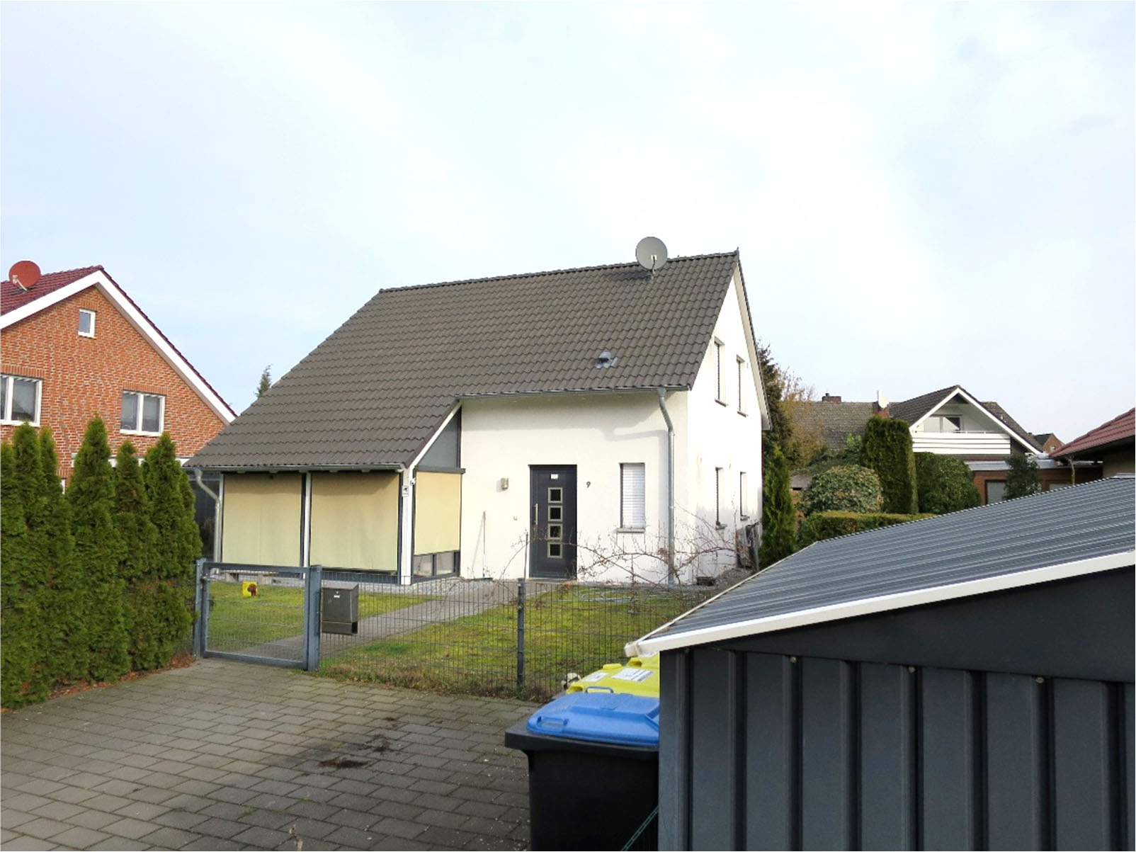 Einfamilienhaus in Oelde, Westrickweg 9, mit weißer Fassade, dunklem Dach und Vorgarten. Eingangstür und Fenster sichtbar