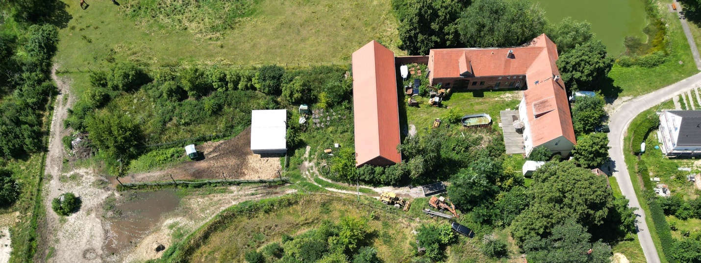 Luftbild des Grundstücks Schönefeld 5 in Niedergörsdorf OT Schönefeld mit Wohngebäude, Nebengebäuden, Garten und umliegender Grünfläche