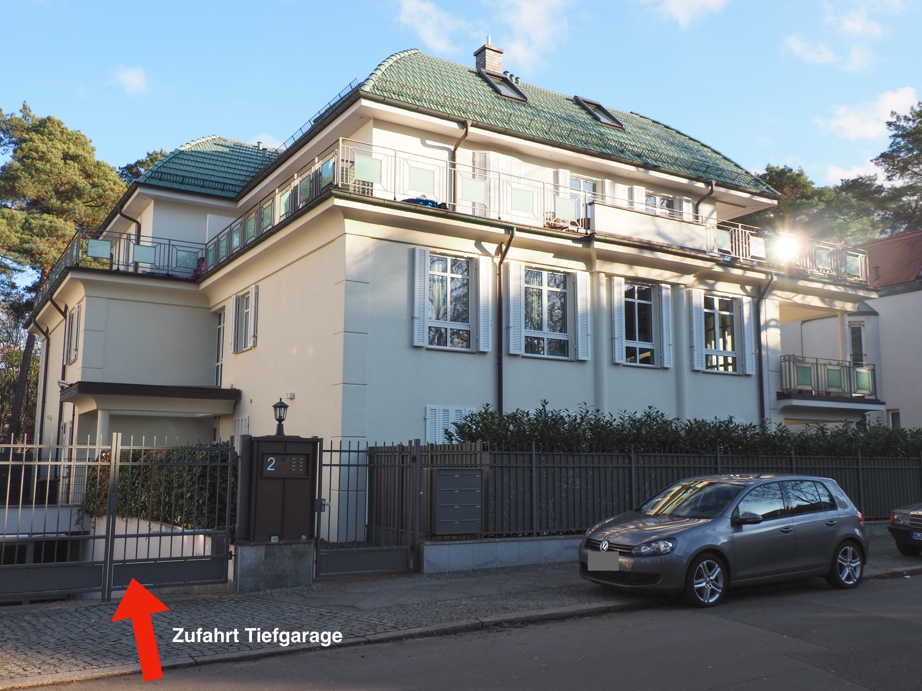 Einfahrt zur Tiefgarage eines Mehrfamilienhauses in Berlin, Kronberger Straße 2, mit geparktem Auto und Einfahrtstor