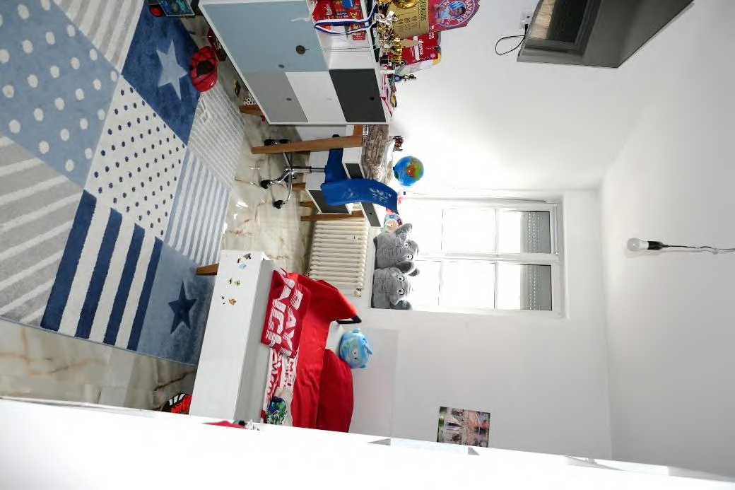 Innenraum eines Hobbyraums mit buntem Teppich, Möbeln, Spielzeug und Fenster. Teil eines Eigentums in Unterschleißheim