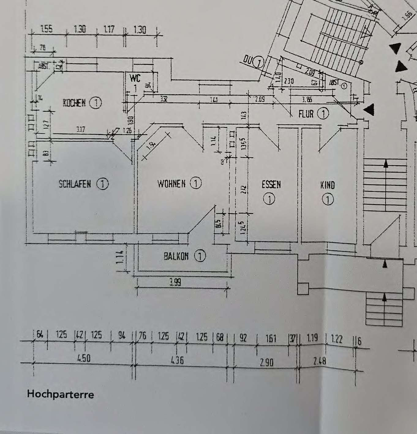 Grundriss der Hochparterre-Ebene mit Wohn-, Schlaf-, Küchen- und Badezimmer sowie Balkon und Flur, mit Maßangaben und Raumbezeichnungen