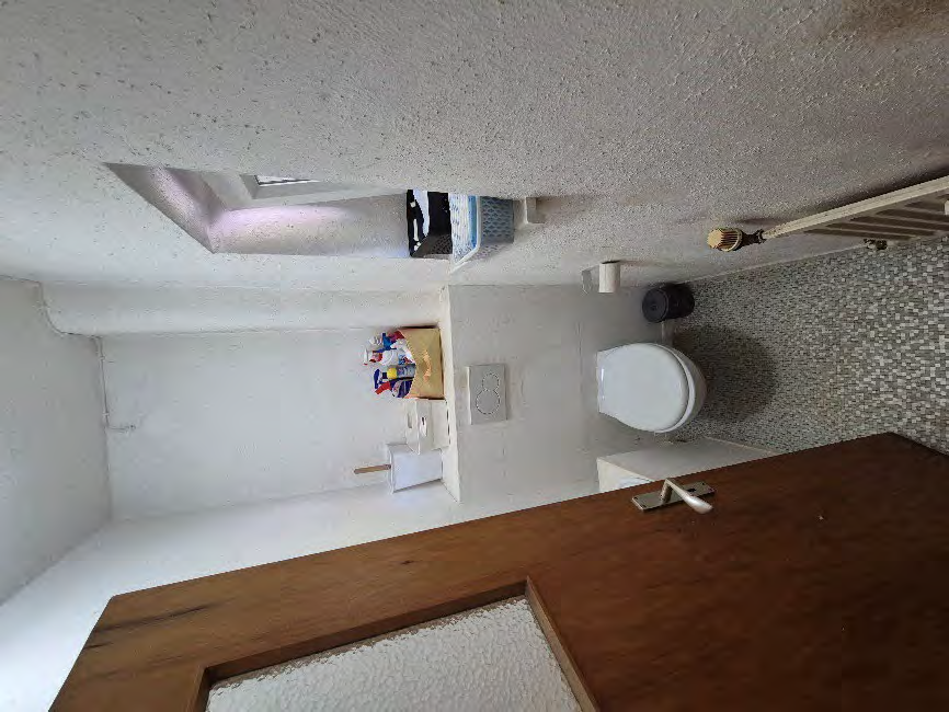 Badezimmer mit Toilette, Fliesenwand, Waschbecken und Holztür im Einfamilienhaus Rezatstraße 7, Oberdachstetten