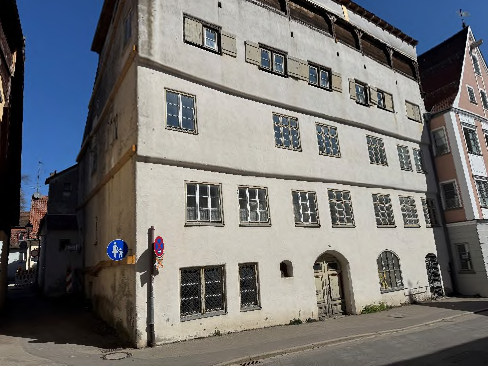 Fassade eines mehrstöckigen Gebäudes an der Ecke Zangmeisterstr. 26 in Memmingen, mit Fenstern, Türen und Straßenzeichen