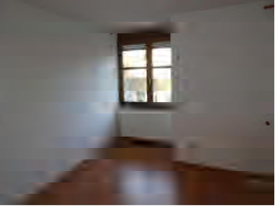 Innenraumansicht einer Garage mit Fenster und Holzboden, leicht verschwommen