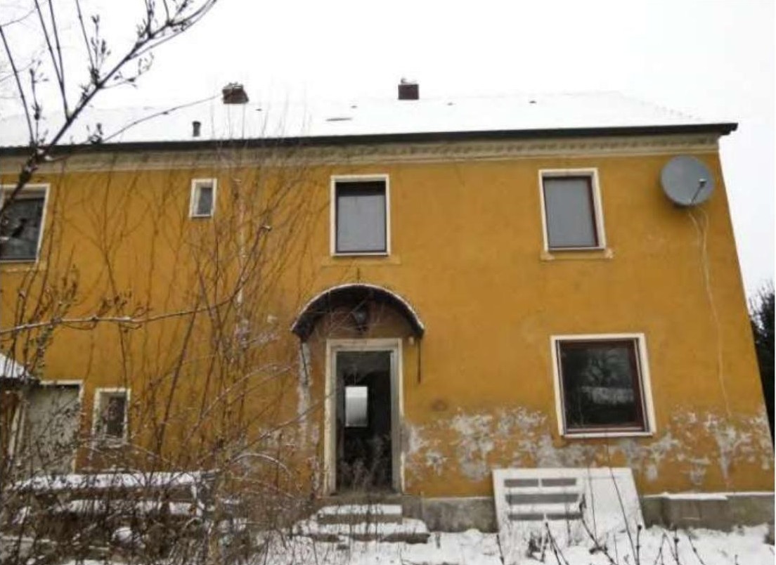 Gelbes zweistöckiges Gebäude mit Eingang, Fenstern und Schnee im Vordergrund, Lamplmühlstr. 23, Püchersreuth