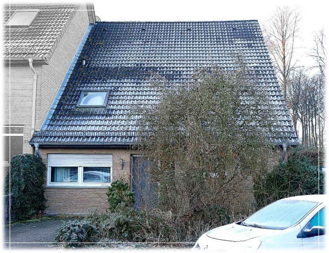 Außenansicht vorne einer Doppelhaushälfte mit Satteldach, Fenster, Eingangstür und Vorgarten in Berlin