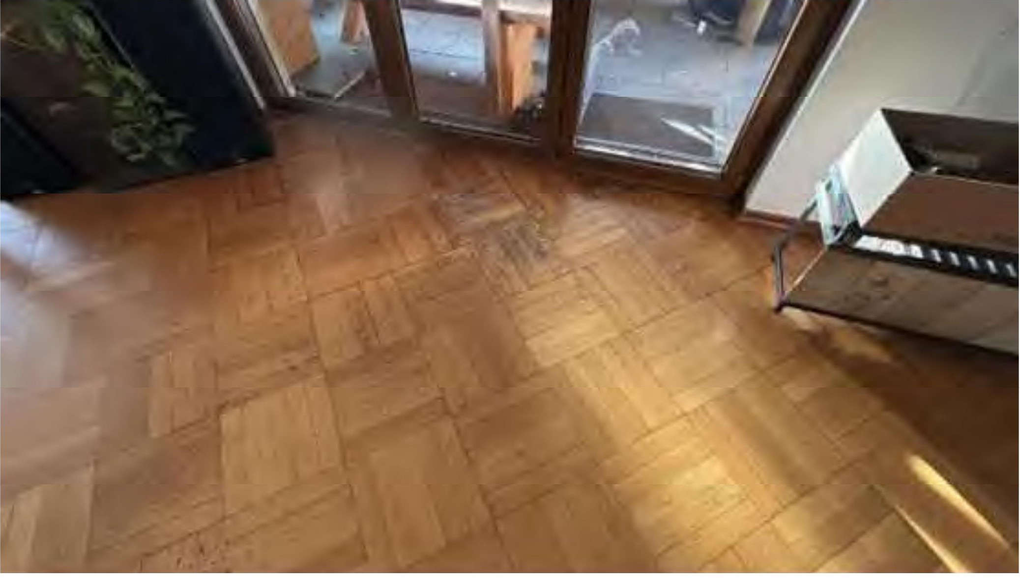 Innenraum mit Parkettboden, Glas türen und einem Metallgestell im rechten Bereich