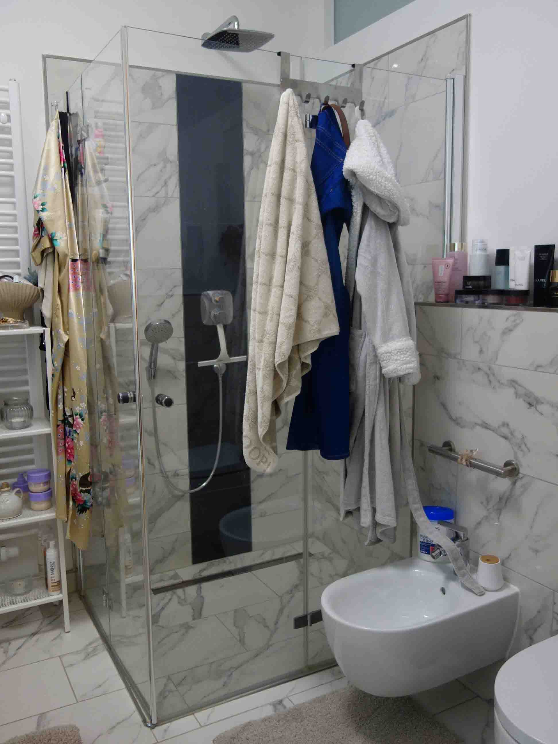 Badezimmer mit Dusche, Waschbecken und Toilette, Marmorfliesen, Handtücher und Badzubehör im Raum Berlin 12587