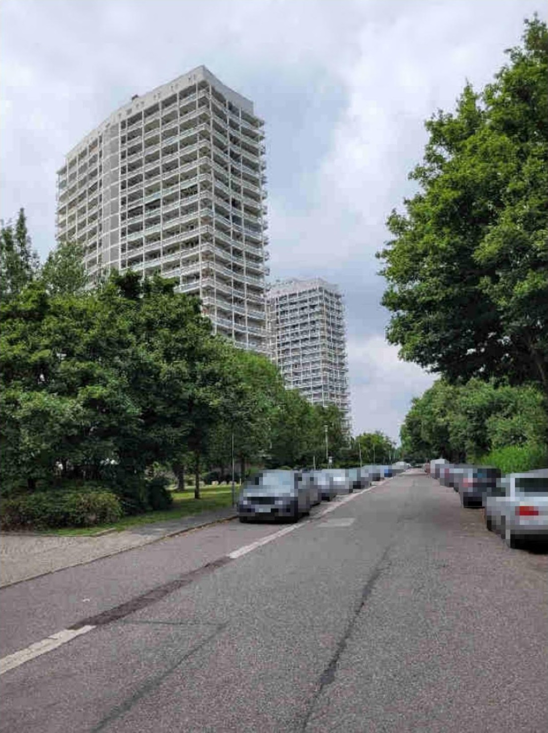 Seitenansicht von Hochhäusern mit Bäumen und geparkten Autos an der Froschlache in Ludwigshafen am Rhein
