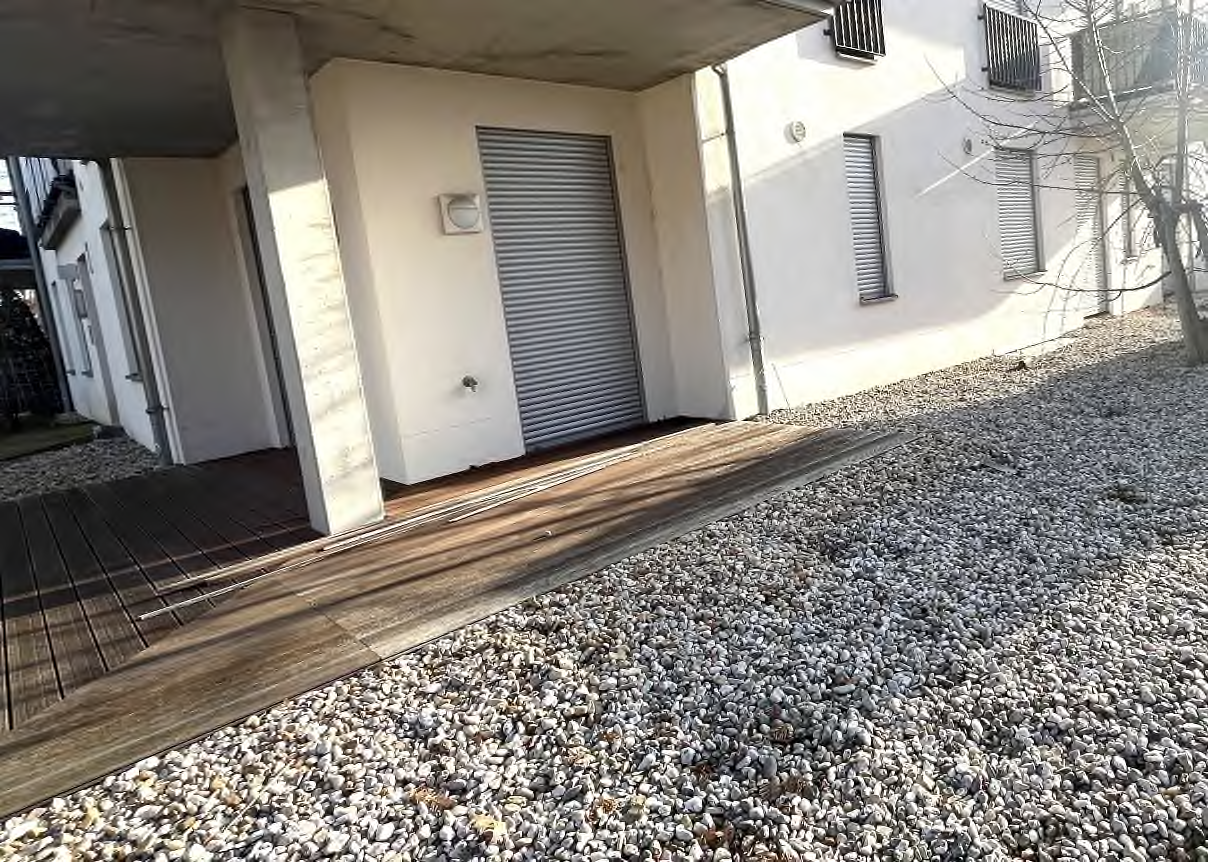Eingangsbereich mit Holzrampe und Rolltor an der Fassade der Eigentumswohnung in Leipzig, Blochmannstraße 2
