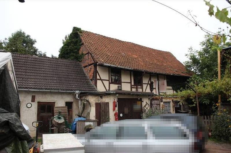 Vorderansicht eines Fachwerkhauses mit Ziegeldach, Eingangstür und angrenzenden Gebäudeteilen sowie Gartenbereich in Gernrode, Marktstraße 7