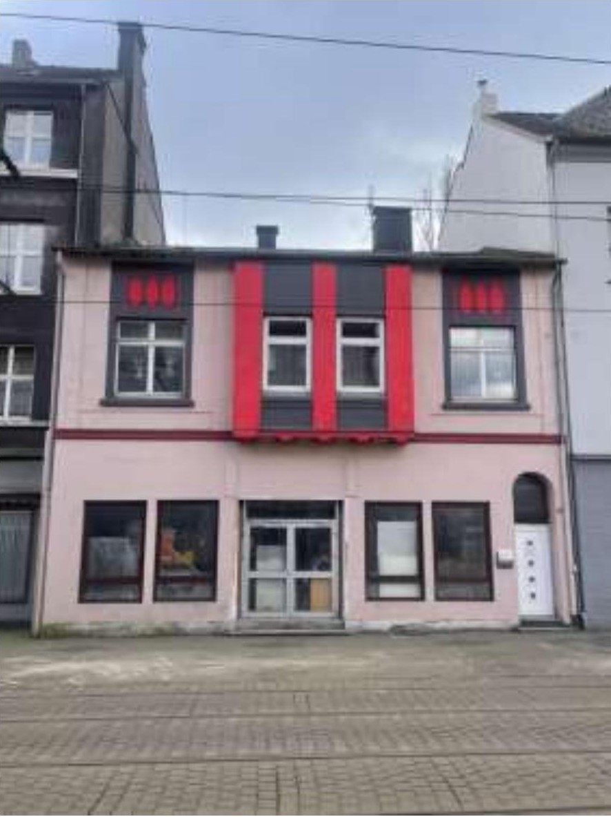 Vorderansicht eines zweistöckigen Wohn- und Geschäftshauses mit rosa Fassade, roten Akzentstreifen und Eingangstür in der Kaiser-Wilhelm-Straße 252, Duisburg