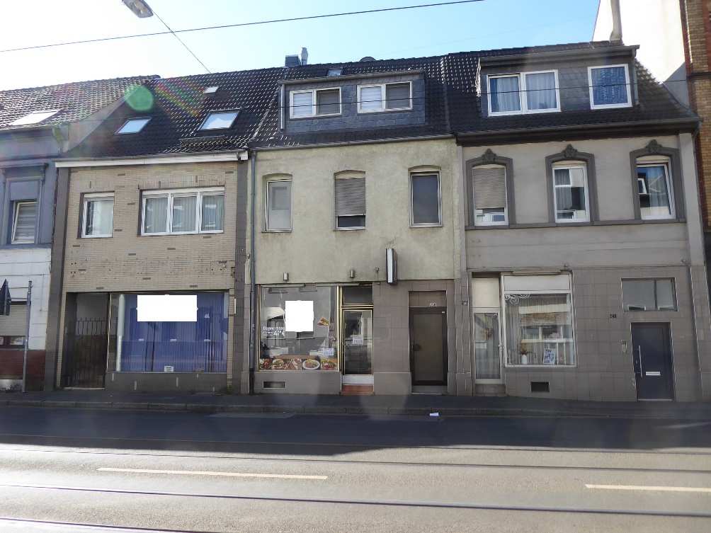 Fassade eines Wohn- und Geschäftshauses in Krefeld, St.-Anton-Straße 238, mit Erdgeschoss-Geschäften und Obergeschossen mit Fenstern und Dachgauben