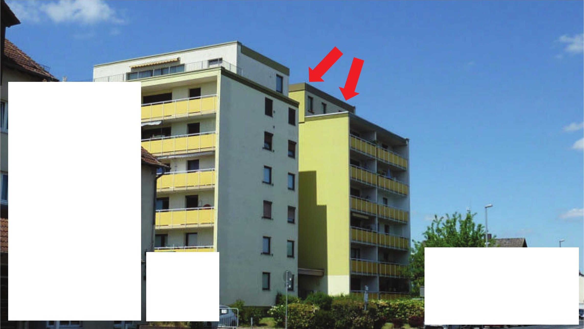 Außenansicht eines mehrstöckigen Wohngebäudes mit gelben Balkonen und hellgrauer Fassade unter blauem Himmel