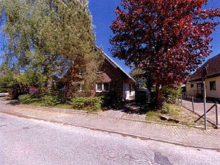 Einfamilienhaus in Ratekau, Süclerstraße 7, mit Dachgeschoss, umgeben von Bäumen und Grünanlagen, vorne gepflasterter Gehweg und Straße