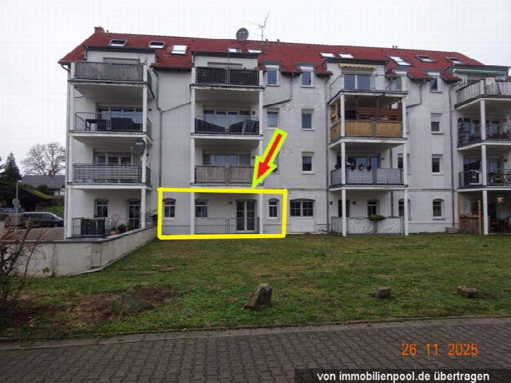 Fassade eines Mehrfamilienhauses in Taucha, Alte Salzstr. 4, mit markierter Eigentumswohnung im Erdgeschoss, weiß verputzt, rotes Dach, Balkone, Vorgarten mit Rasen