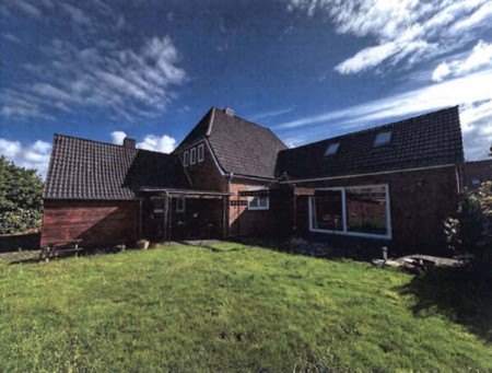 Einfamilienhaus mit dunklem Satteldach und Holzfassade, Vorgarten mit Rasen, Hauptstraße 26, 25866 Mildstedt