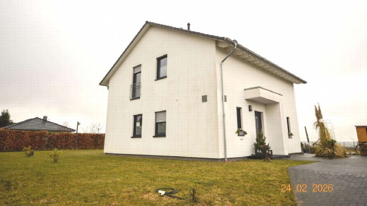 Einfamilienhaus in Nordwestuckermark, Horster Straße 18c, weiß verputzt, zweigeschossig, mit dunklen Fensterrahmen und Vorgarten
