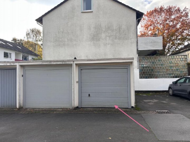 Garage mit grauer Rolltür an der Ludwig-Jahn-Straße 16D in Hannover, 30629, neben einem Wohnhaus mit Glassteinmauer