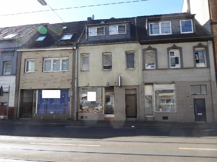 Fassade eines Wohn- und Geschäftshauses in Krefeld, St.-Anton-Straße 238, mit Erdgeschoss-Geschäften und Obergeschossen mit Fenstern und Dachgauben