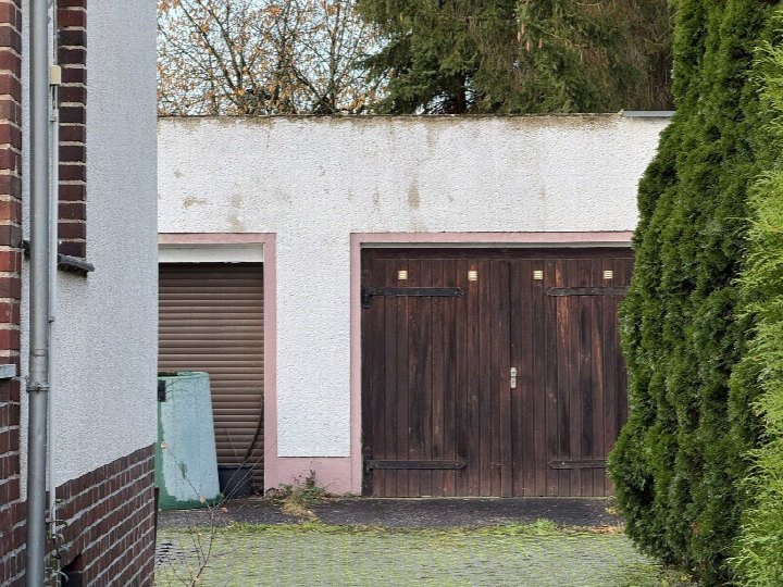 Garage mit Holztoren und Nebeneingang mit Rollladen, Teil eines Grundstücks in Böhlen, Ferdinand-Lassalle-Str. 11