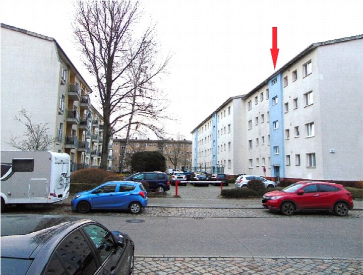 Außenansicht der Wohnanlage Dreilindenstraße 60 in Berlin mit mehreren geparkten Fahrzeugen und einem markierten Wohnungsstandort