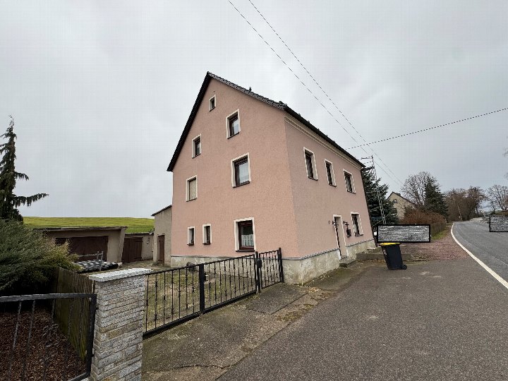 Einfamilienhaus in Hainichen, Berthelsdorfer Straße 39, mit rosa Fassade, dunklem Satteldach und Eingangsbereich mit schmiedeeisernem Zaun