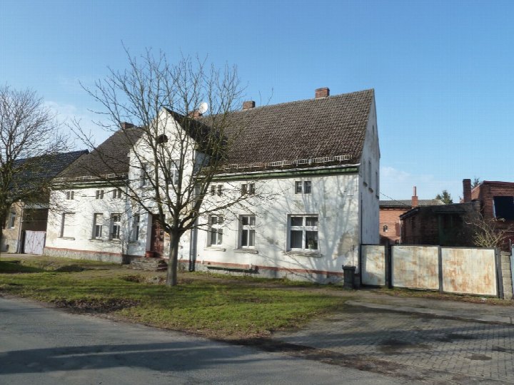 Seitenansicht eines weißen Einfamilienhauses mit Satteldach, Fenstern und umliegendem Grün in Gumtow, Schönhagener Dorfstraße 17